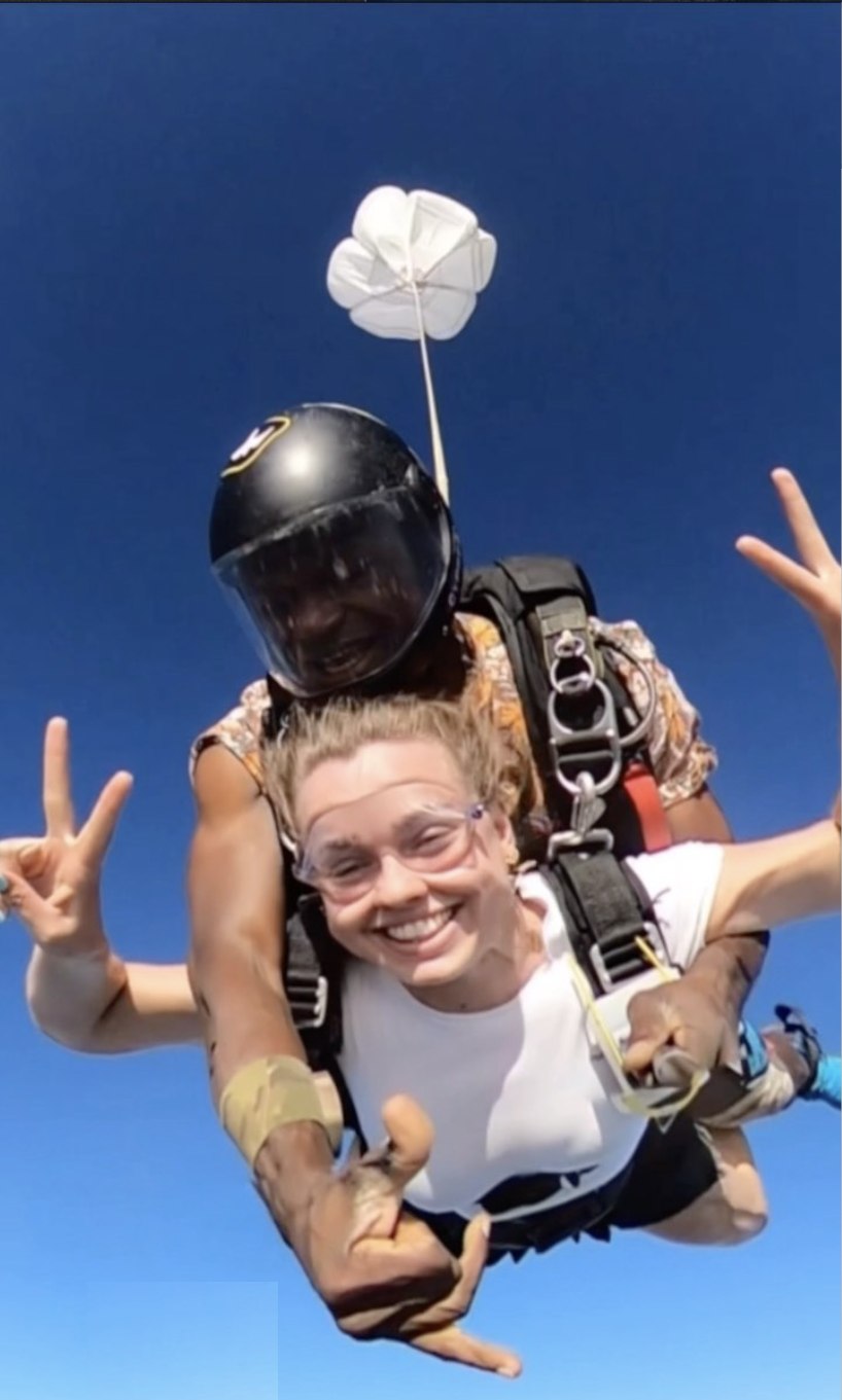 Passagère souriante en chute libre lors d'un saut en tandem avec Vewuha Parachutisme